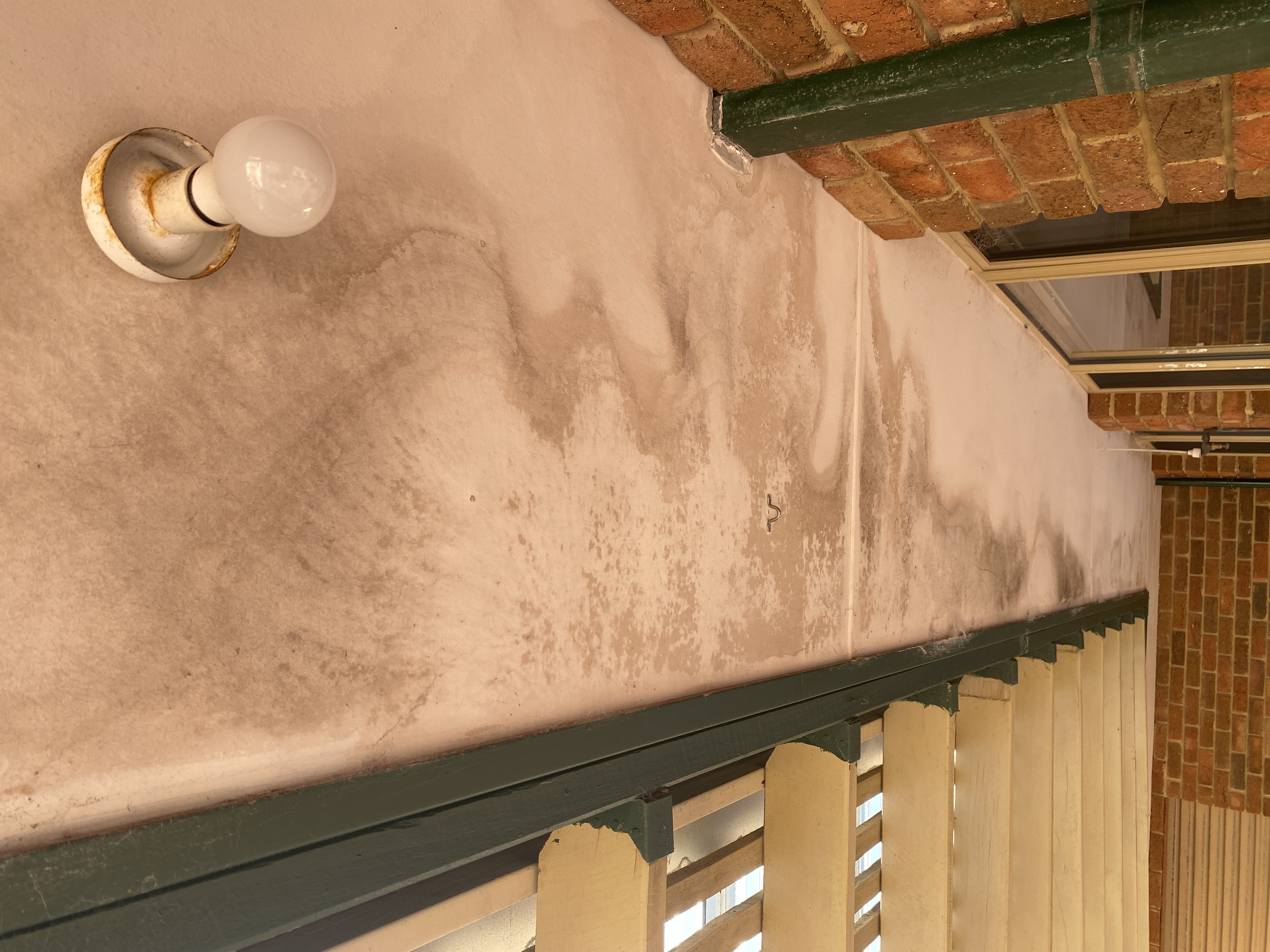 Ceiling water damage from roof overflow due to blocked downpipes