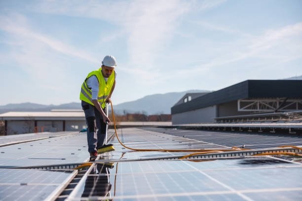 Technician cleaning solar panels using purified water system